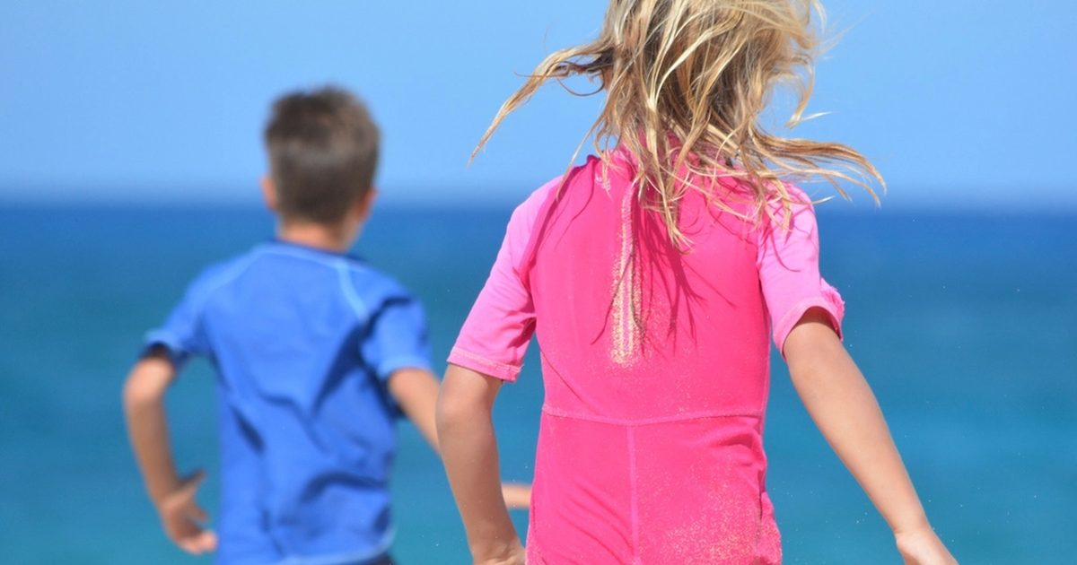 Two children running into the sea on a summer day