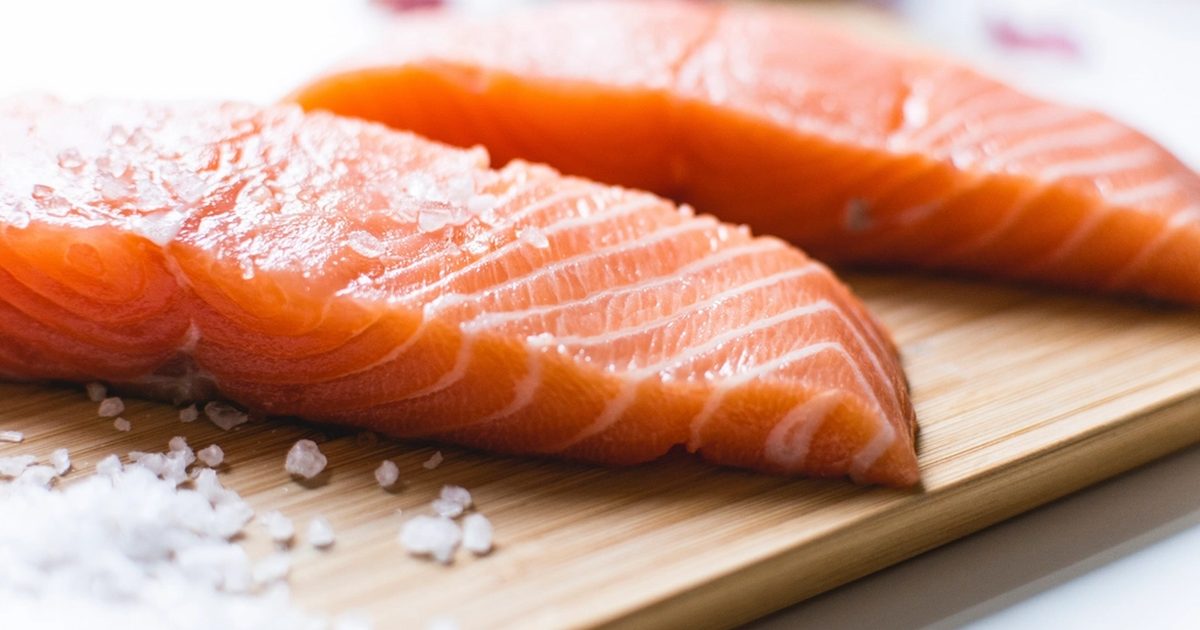 Salmon fillets on a wooden board with sea salt